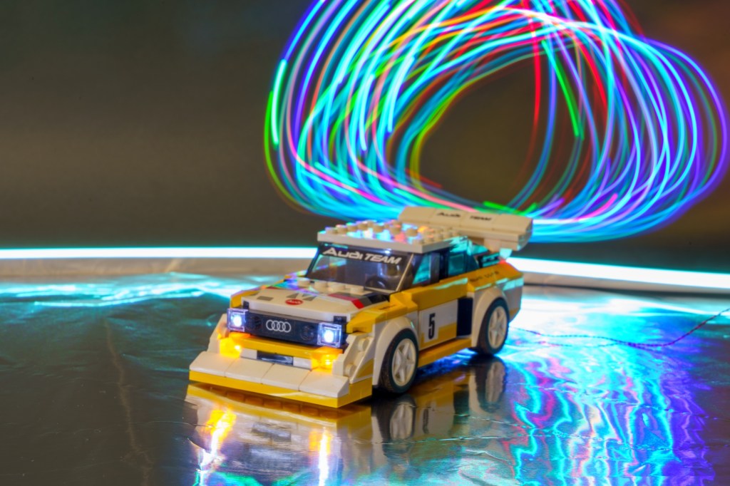 Light painting photo of a Lego car and mini figures