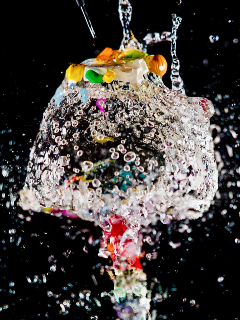 Two LEGO mini figures bursting out of a water bomb balloon 