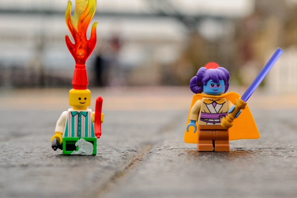 Two LEGO figures, one with a flame on its head and a Jedi character