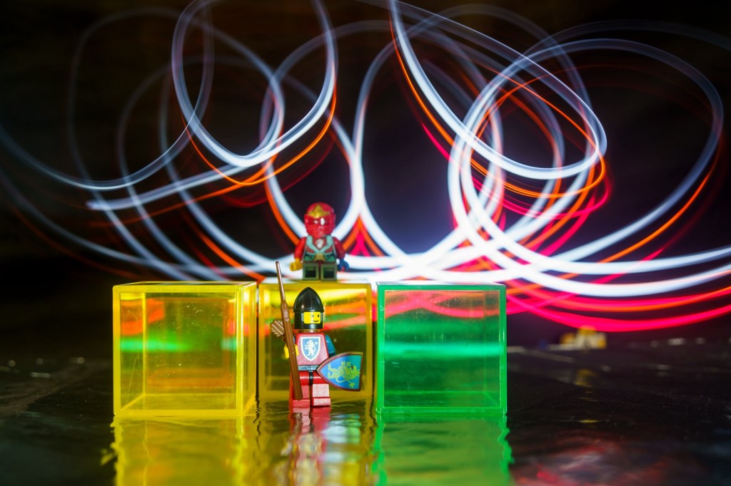 A LEGO knight and a LEGO ninja surround by light traces 