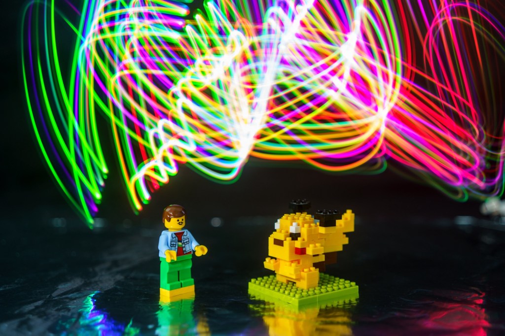 Lego man with a Lego Pikachu with light traces in the background