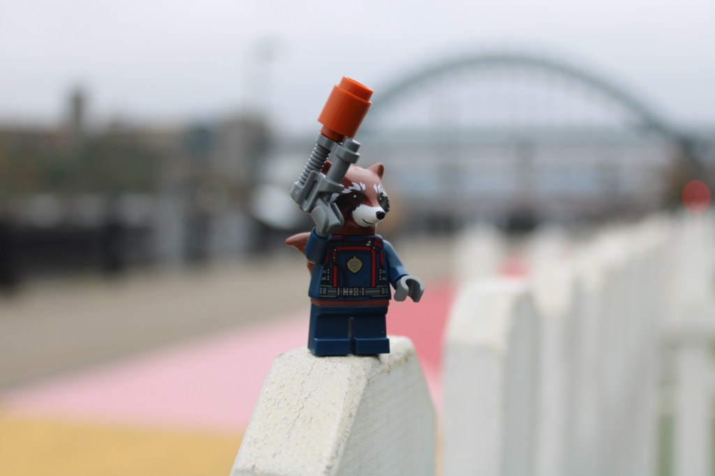 Lego figure rocket from Guardians of the Galaxy in front of the Tyne bridge